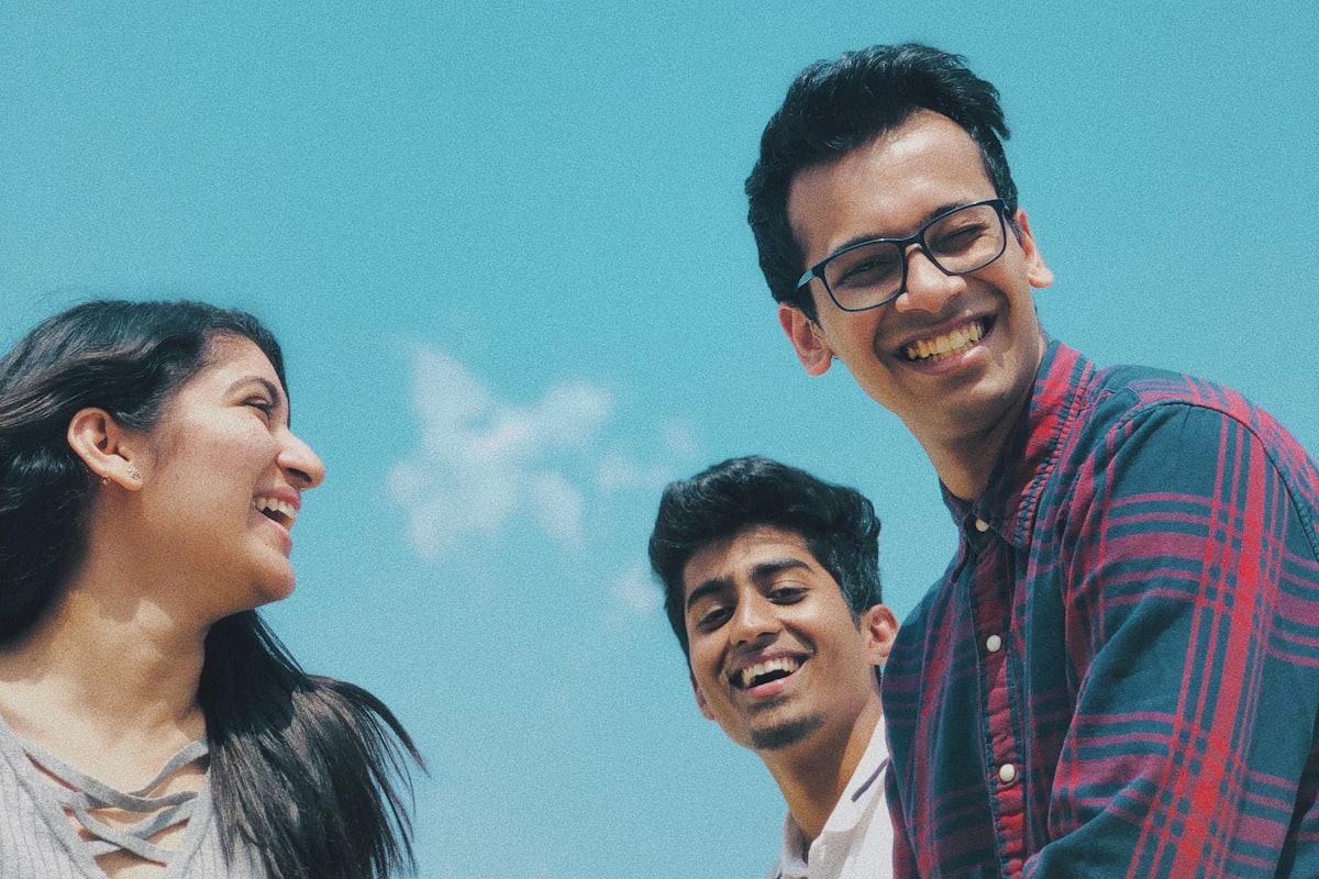 Three young founders laughing together outdoors