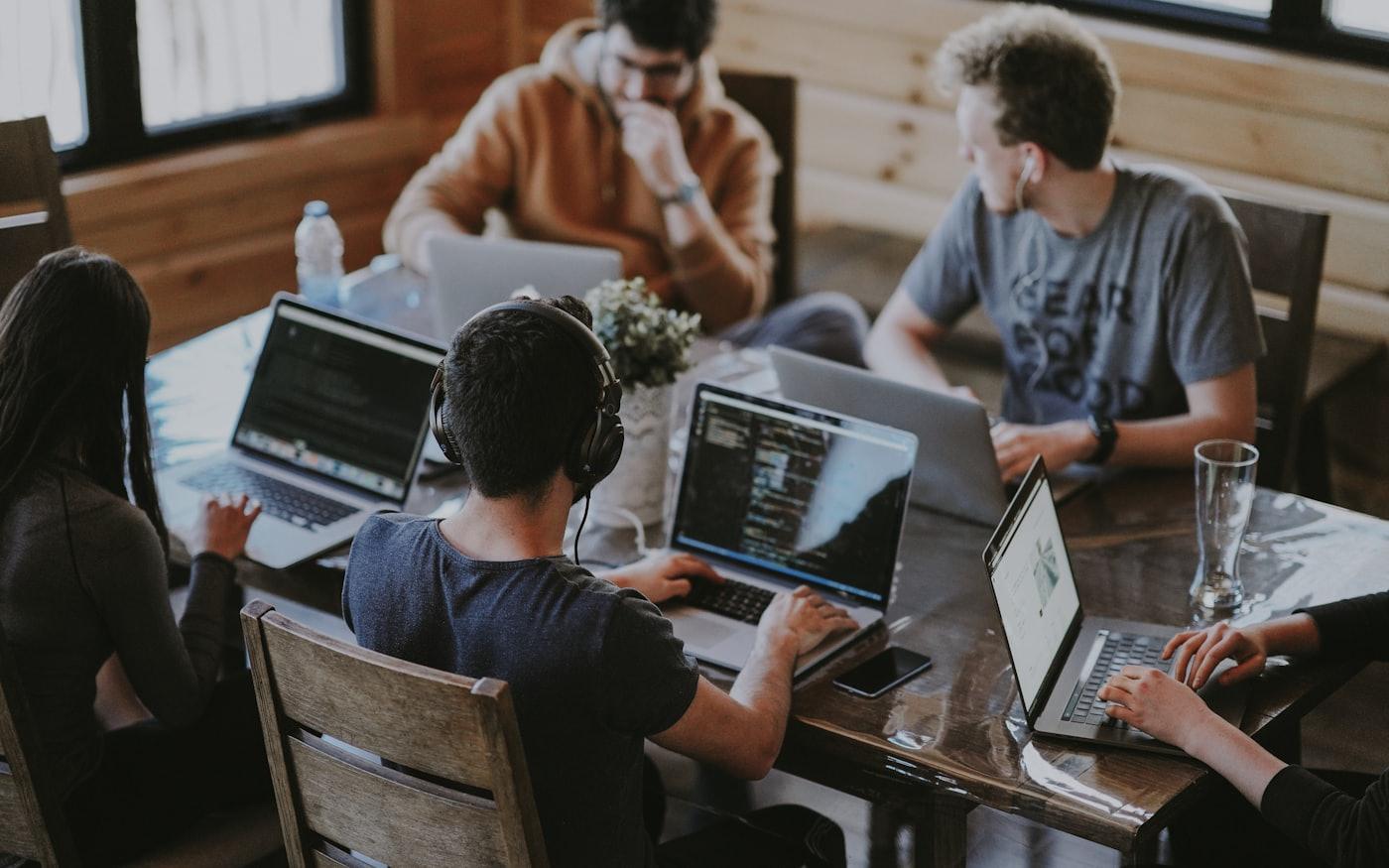A team of developers working together at a long table