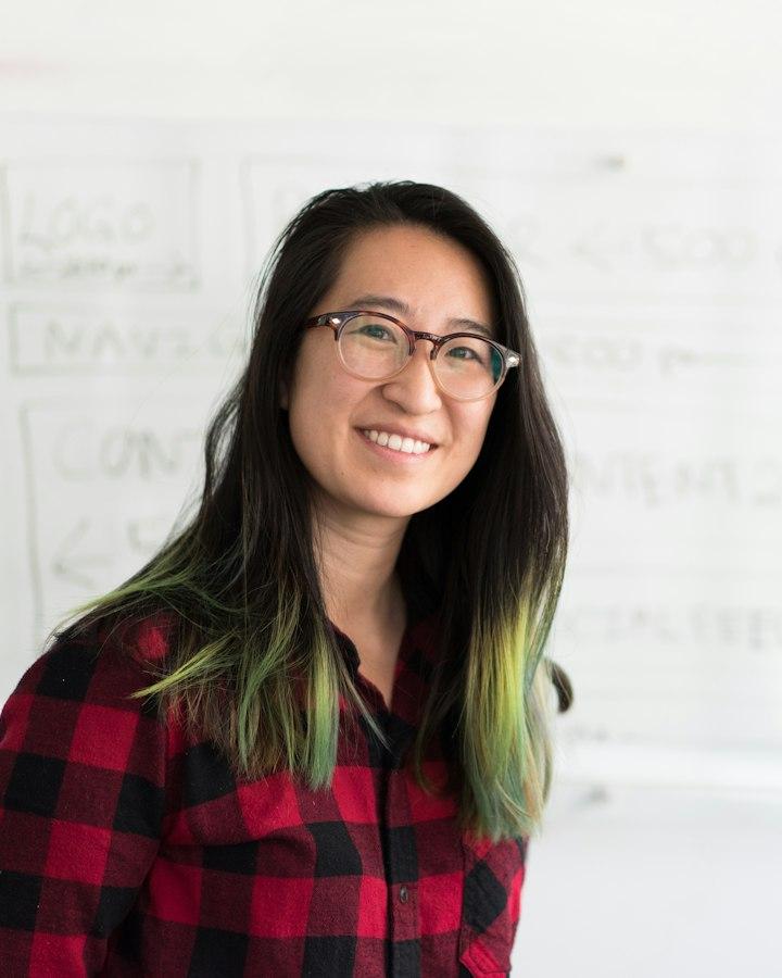 A developer smiling at a whiteboard