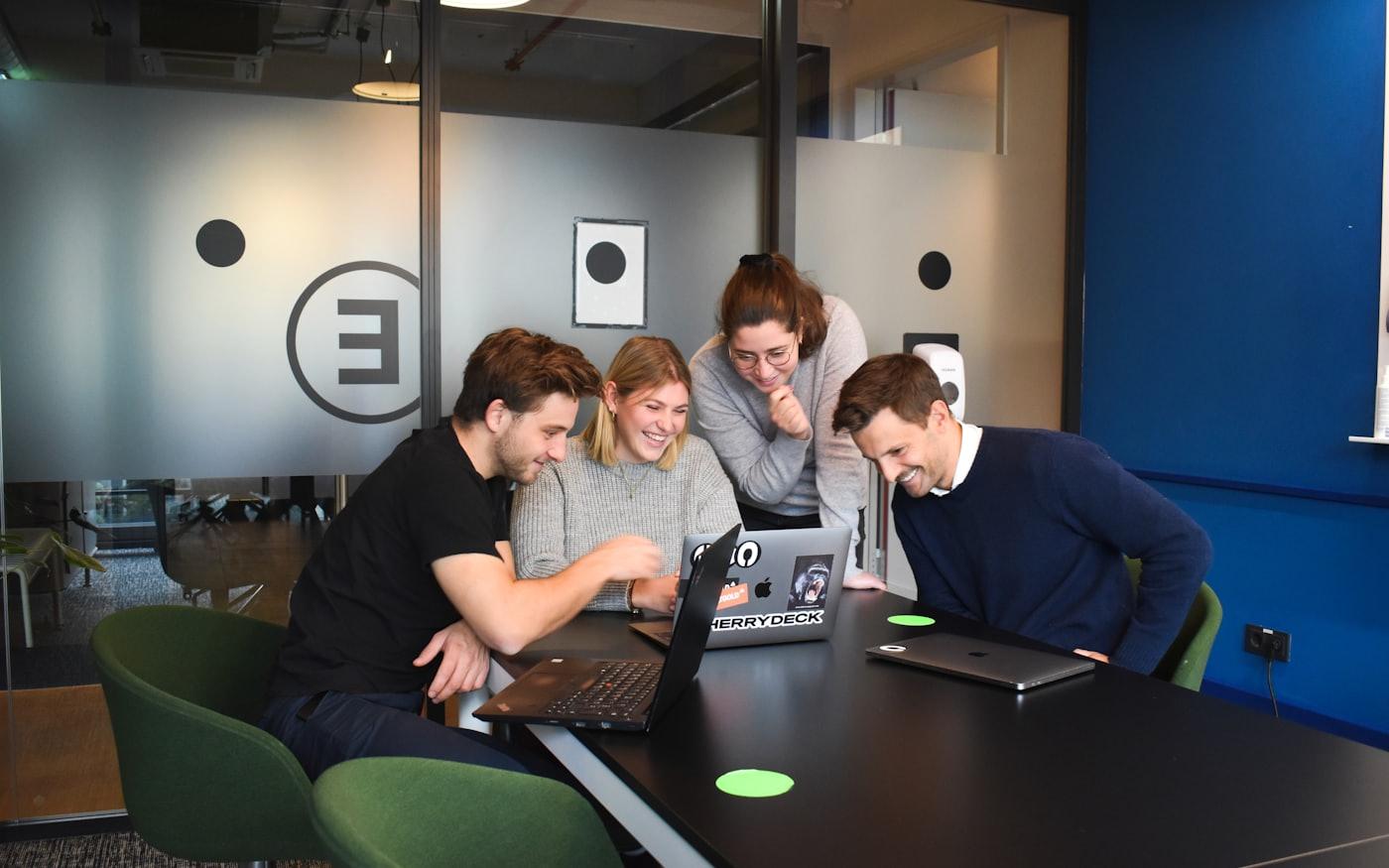 A team working through a plan together around a laptop